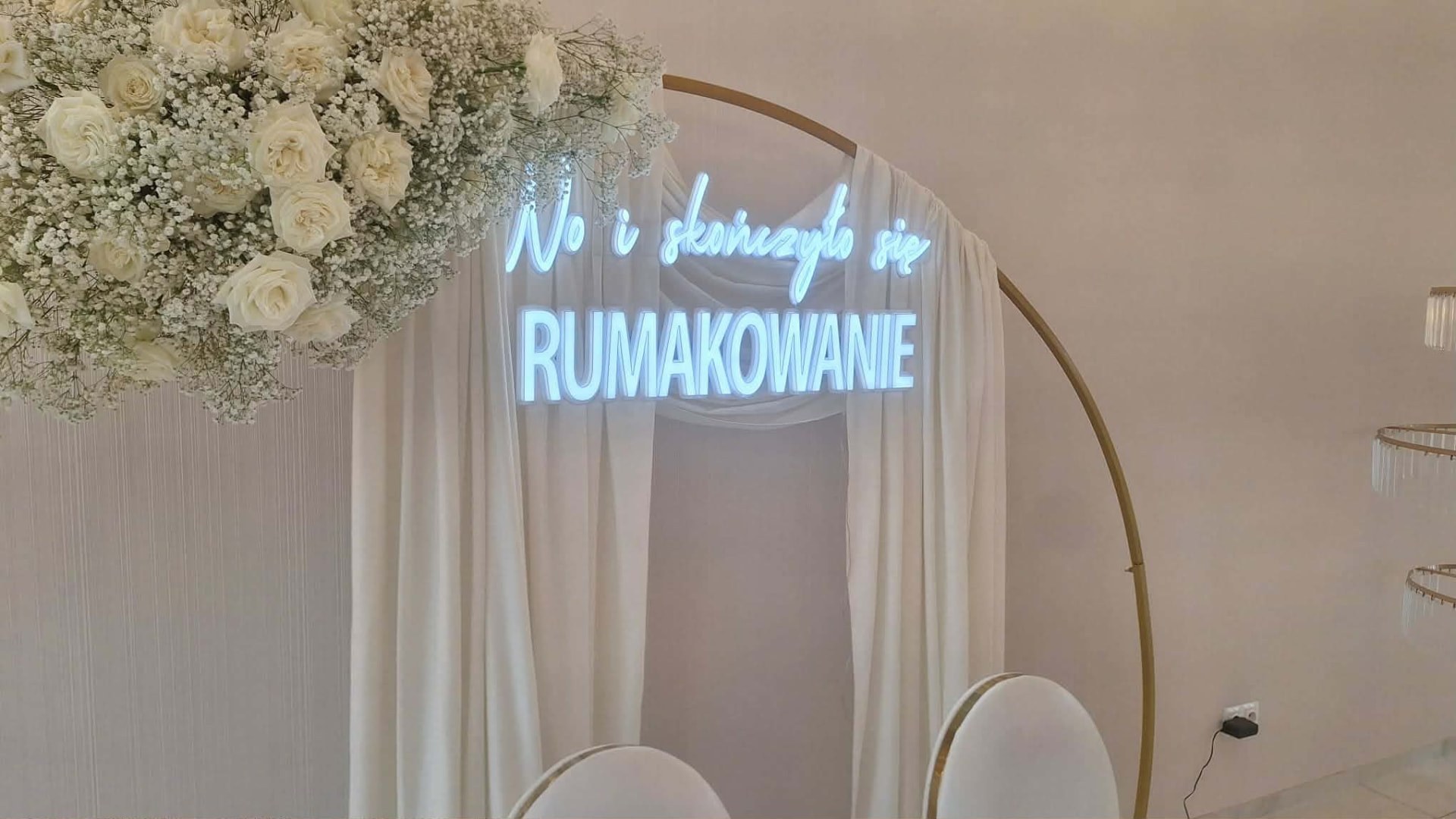 Neon „No i skończyło się rumakowanie” na okrągłym stelażu nad stołem pary młodej
